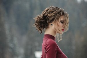 Woman with curly hair wearing a messy bun